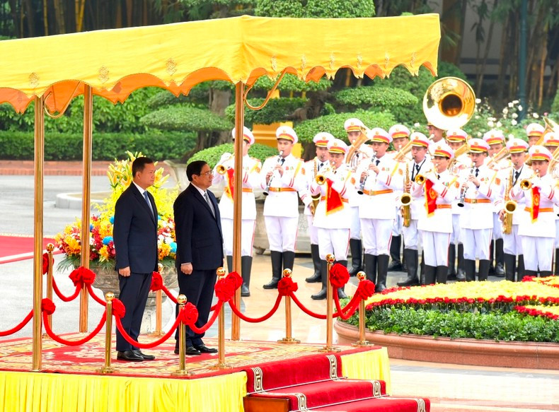 Prime Minister Pham Minh Chinh and his Cambodian counterpart Hun Manet perform the flag salute ceremony.
