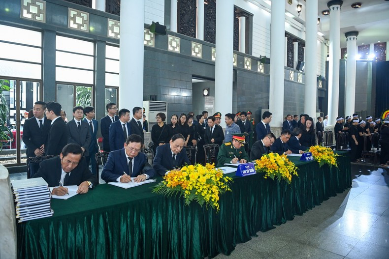 Current and former leaders of Nhan Dan write in the condolence book.