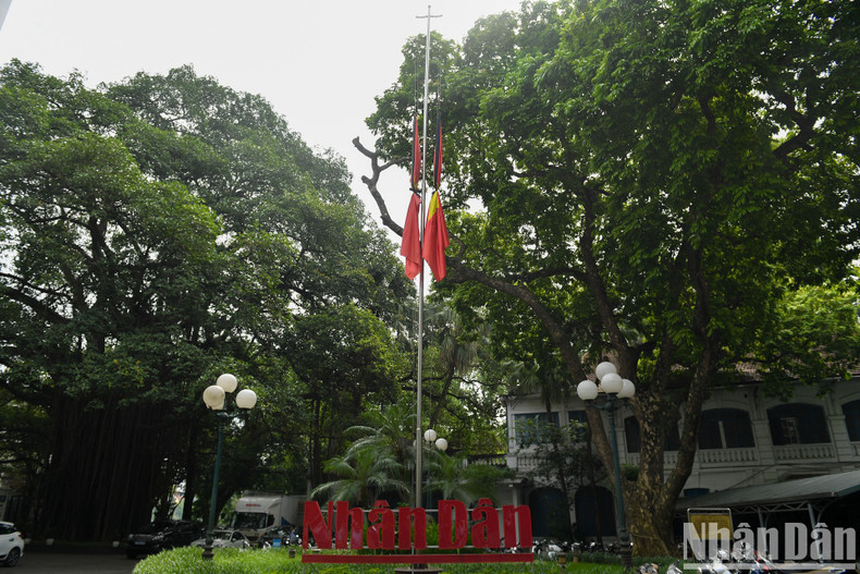 The half-mast flags at the head office of Nhan Dan Newspaper.