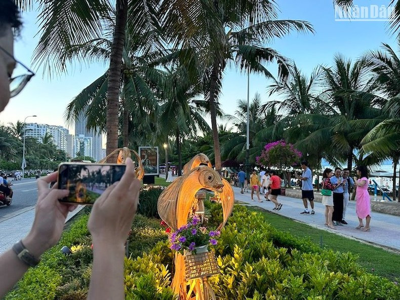 A tourist takes a photo of the flower walk. A tourist takes a photo of the flower walk.