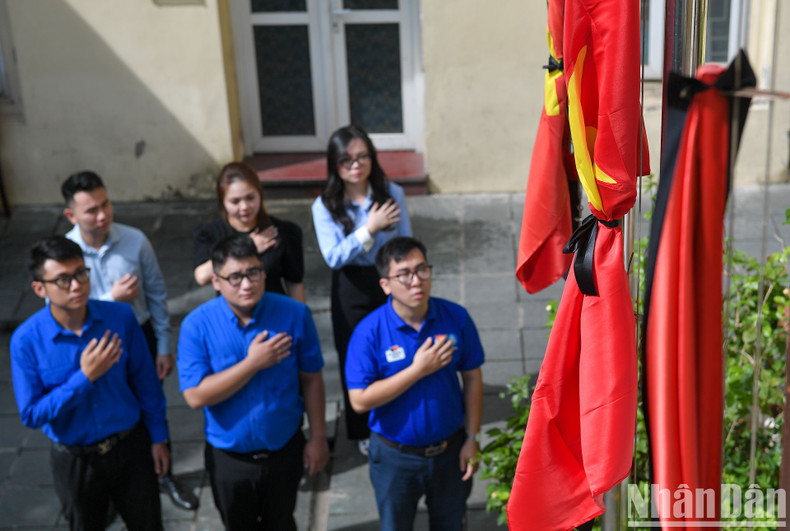 Officials and members of the Hanoi Youth Union stand before the half-mast flags to commemorate General Secretary Nguyen Phu Trong.