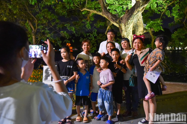 Members of a family pose for a photo by Hoan Kiem Lake. Members of a family pose for a photo by Hoan Kiem Lake.