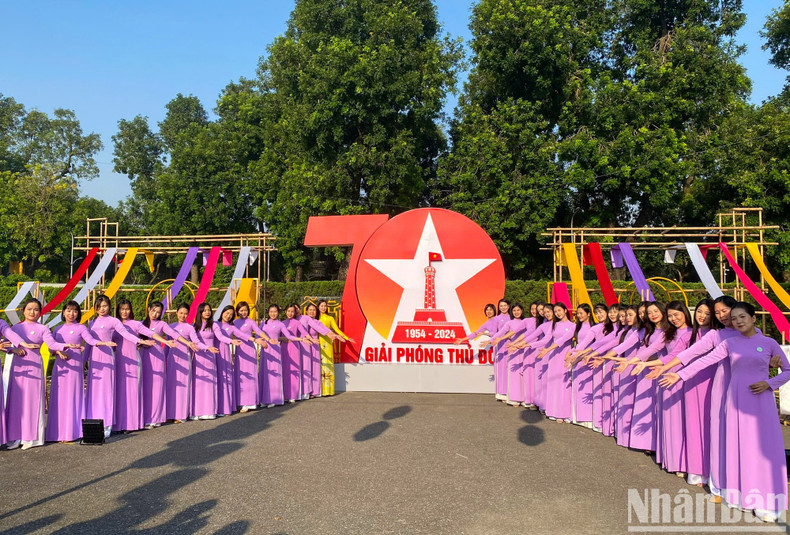 Women in ao dai pose for a photo in front of a large billboard celebrating the 70th anniversary of Hanoi’s liberation. Women in ao dai pose for a photo in front of a large billboard celebrating the 70th anniversary of Hanoi’s liberation.