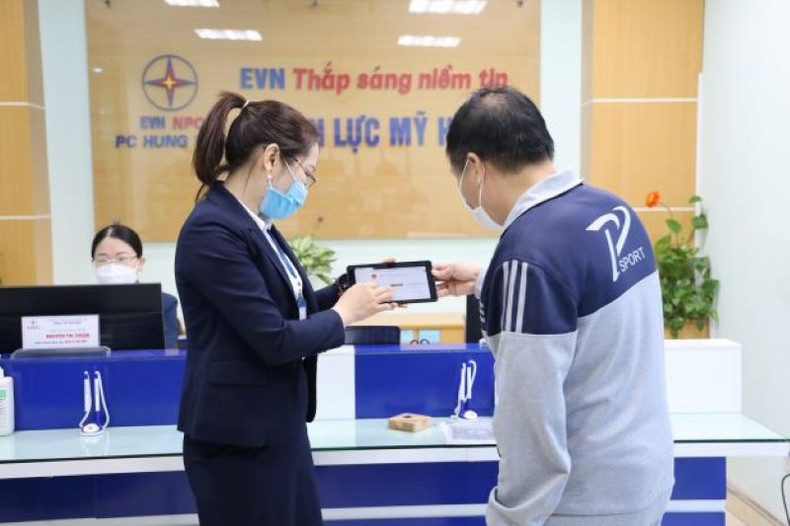 A power official in My Hao Town instructs a customer on how to use the national public service portal.