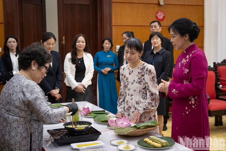 The two ladies make banh com together.