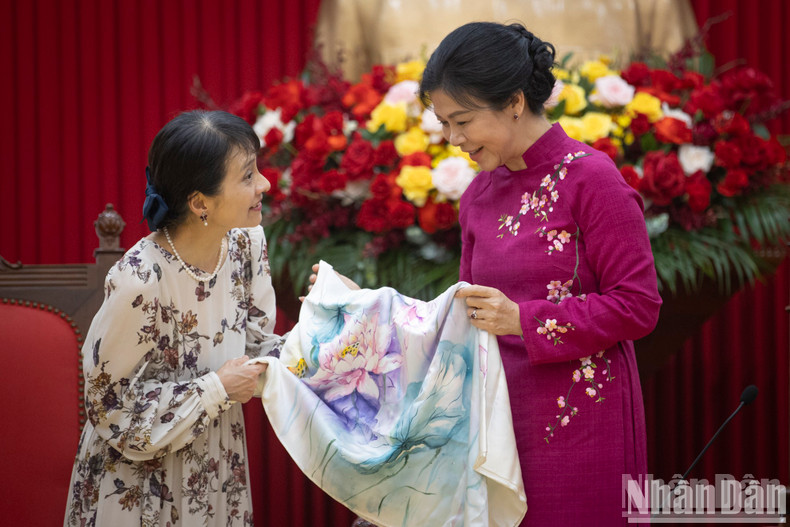 Lady Ngo Phuong Ly presents a silk scarf with lotus and chrysanthemum patterns to Lady Ishiba Yoshiko.