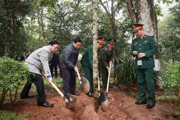 PM Pham Minh Chinh joins in tree planting at the relic site. (Photo: VNA)