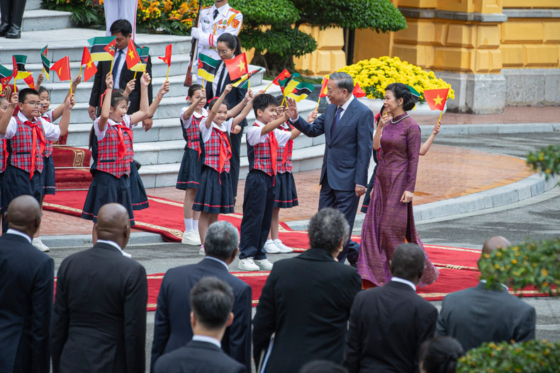 General Secretary and President To Lam and his wife wave at the children.