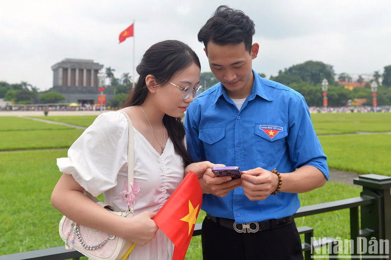 Two young people stand in Ba Dinh Square, with President Ho Chi Minh Mausoleum in the background. Two young people stand in Ba Dinh Square, with President Ho Chi Minh Mausoleum in the background.