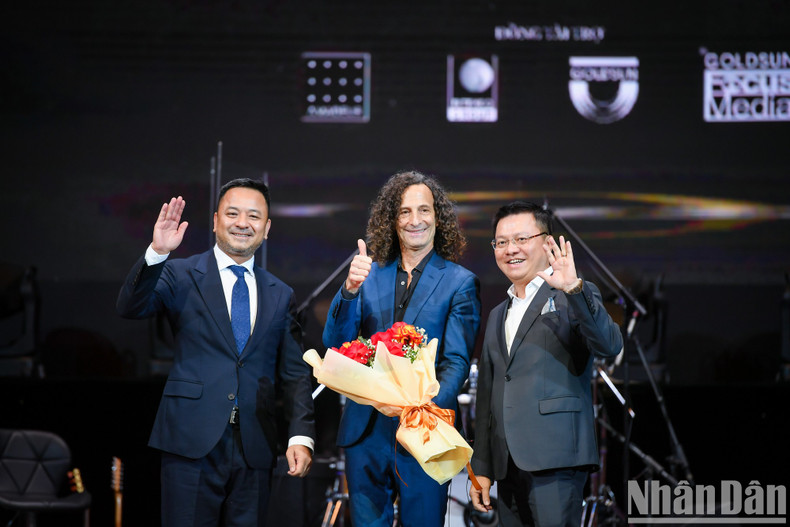 Kenny G, Nhan Dan’s Editor-in-Chief Le Quoc Minh and IB Group Vietnam Chairman Nguyen Thuy Duong wave to the audience at the end of the show.