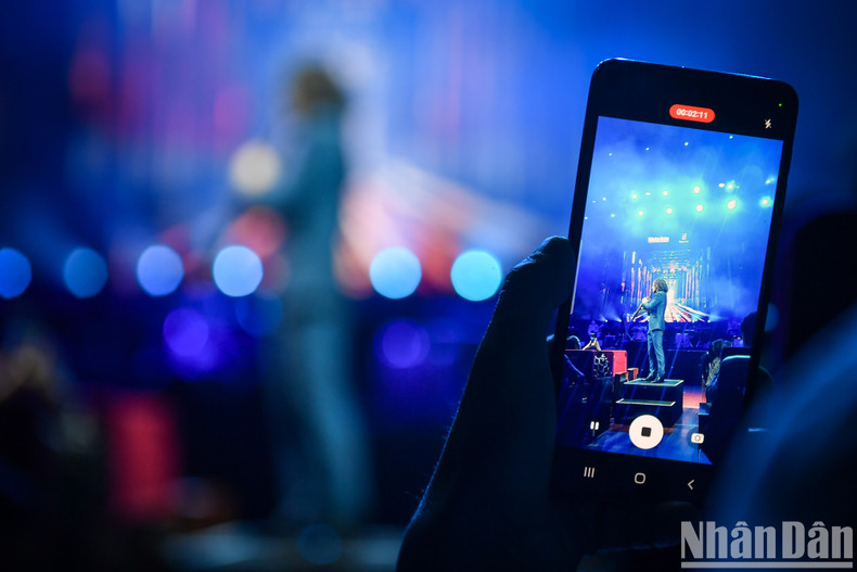 Vietnamese fans capture the moment their idol is performing.