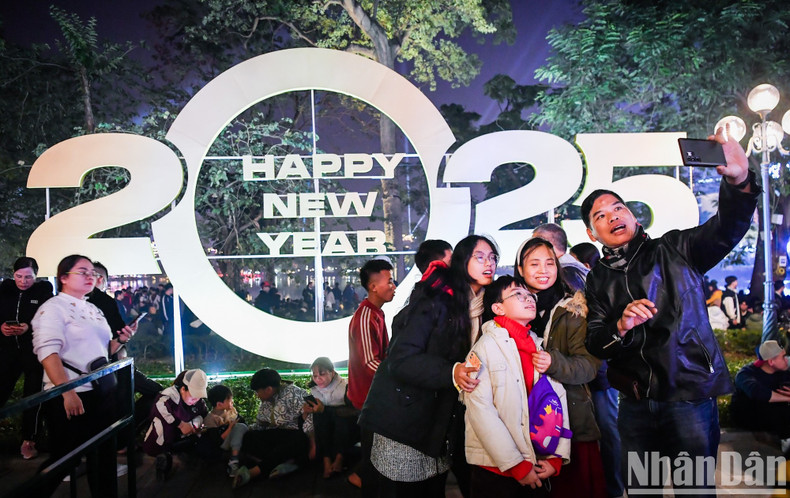 A family takes a selfie against the backdrop of an installation with the number 2025. A family takes a selfie against the backdrop of an installation with the number 2025.