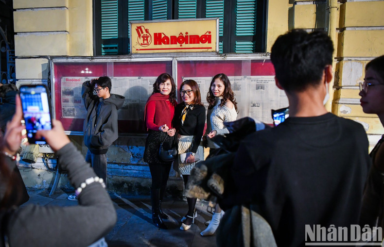 Revellers pose for photos in front of the Ha Noi Moi Newspaper office on New Year’s Eve. Revellers pose for photos in front of the Ha Noi Moi Newspaper office on New Year’s Eve.