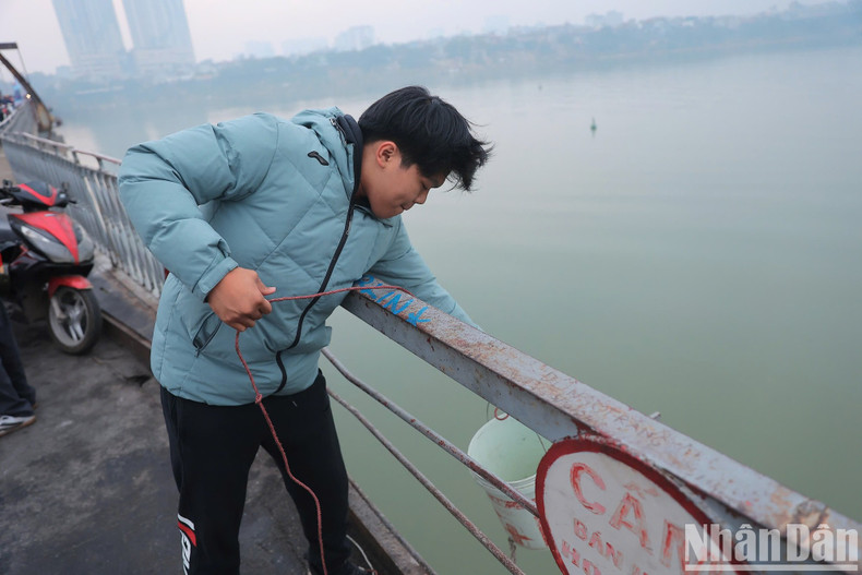 The buckets containing fish were lowered close to the water’s surface using the pulley system. The buckets containing fish were lowered close to the water’s surface using the pulley system.