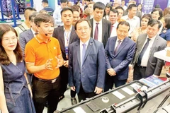 Scientists visit a technology product exhibition area at the Viet Nam Technology and Innovation Connectivity event.