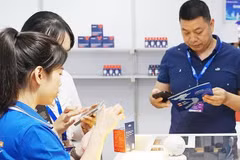 Customers use smartphones to access product information through QR codes. Photo: NAM ANH