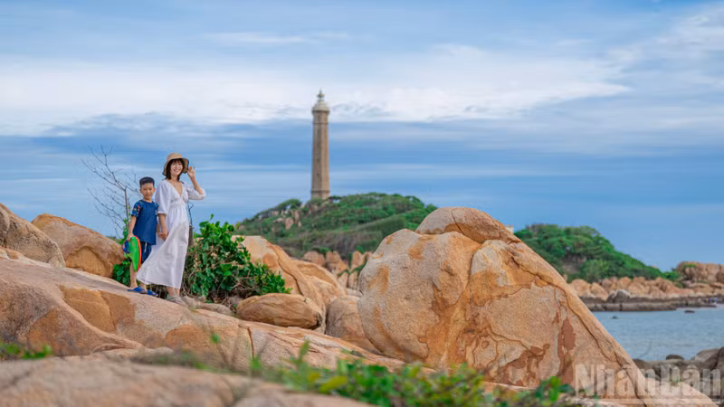 Visitors pose for photographs with Ke Ga Lighthouse in the background during this rare low-tide occurrence.