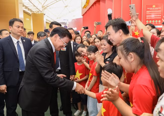 Party General Secretary and President of Laos Thongloun Sisoulith meets Vietnamese people at the exhibition. (Photo: VNA)