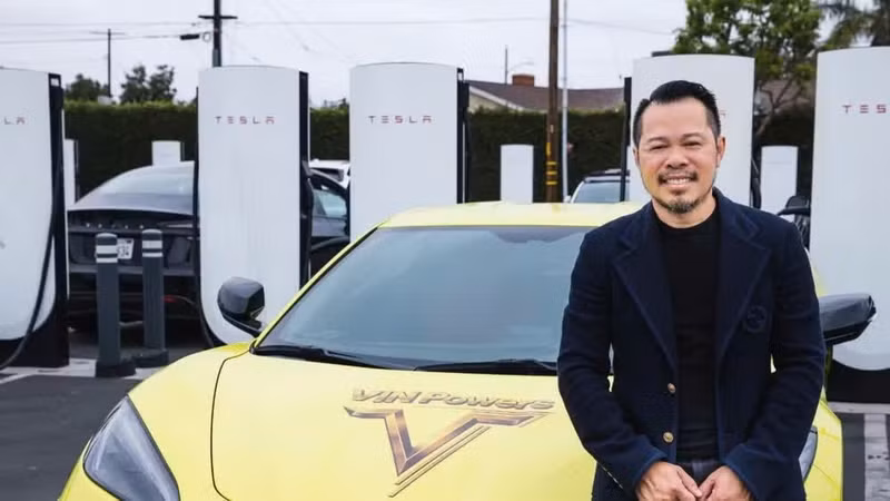 Vinpowers CEO Mike Duong stands next to a Tesla charging station.