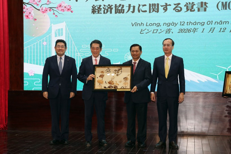 Secretary of the Vinh Long Party Committee Tran Van Lau (second from right) presents a gift to Ehime Governor Tokihiro Nakamura at the MoU signing ceremony on January 12. (Photo: VNA)