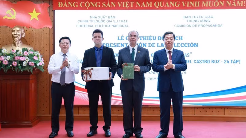 Tran Thanh Lam, Deputy Head of the Central Commission for Communications and Education and Assoc Prof, Dr Vu Trong Lam, Director of the Truth National Political Publishing House, present the book collection to the Cuban Embassy in Viet Nam.