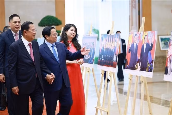 Prime Minister Pham Minh Chinh and President of the Cambodian People's Party (CPP) and President of the Cambodian Senate Hun Sen visit a photo exhibition on bilateral cooperation held by the Viet Nam News Agency. (Photo: VNA)