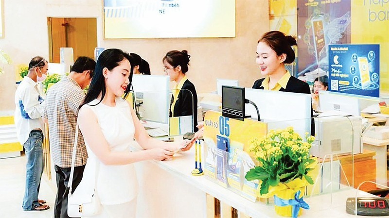 A Nam A Bank teller offers advice to a customer.