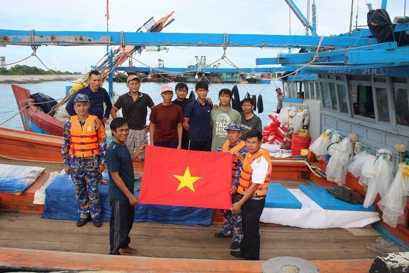 Officers and soldiers on Song Tu Tay Island present gifts and food to fishermen as they take shelter from storms.