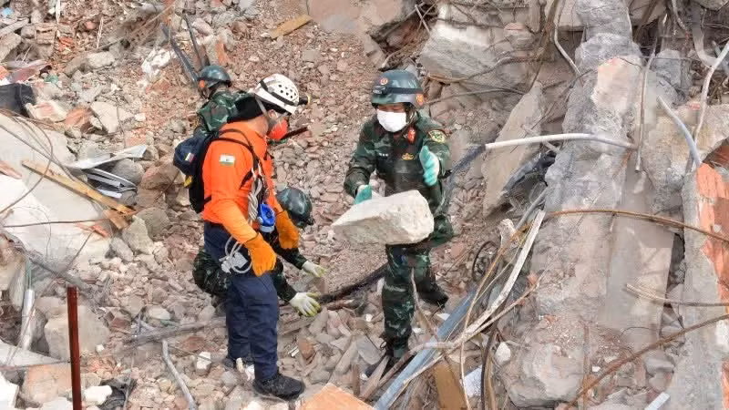 Vietnamese rescue personnel search for victims beneath the rubble. (Photo: VNA)