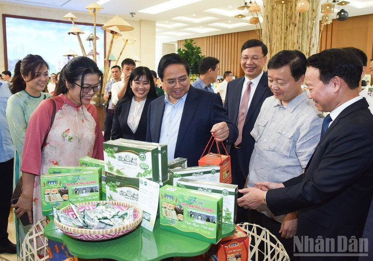 Prime Minister Pham Minh Chinh visits a booth displaying OCOP products. (Photo: Tran Hai)