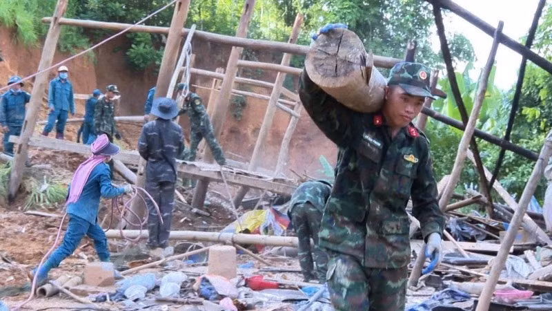 Military officers help people relocate their property to safety.