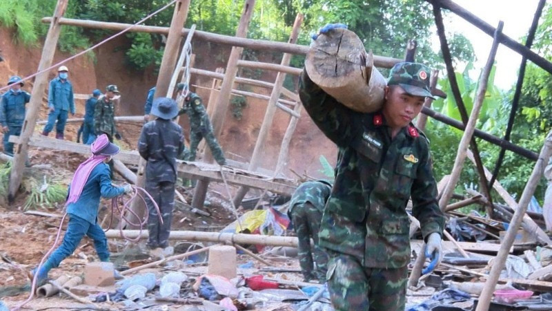 Military officers help people relocate their property to safety.