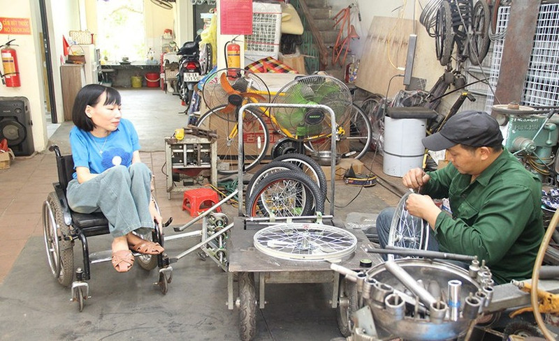Nga discusses tricycle designs for the disabled with her companion.