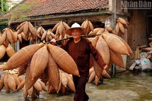 Artisan Luong Son Bac carries bamboo fish traps on his shoulder. (Photo: LINH VU)