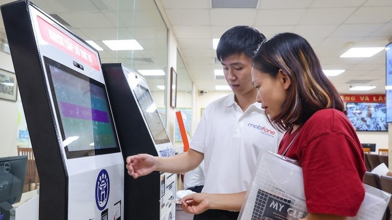 MobiFone staff instruct people on how to use the Administrative Procedures Information System. 9-7-hotro3.jpg