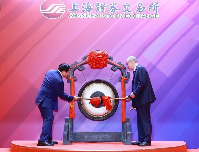 Prime Minister Pham Minh Chinh (L) performs the gong-beating ceremony to open a trading session at the Shanghai Stock Exchange. (Photo: VNA) 26-6-thu-tuong-chung-khoan-thuong-hai-2.jpg