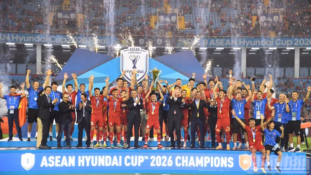 The Viet Nam team lift the championship trophy, with congratulations from the President of the ASEAN Football Federation and the President of the World Football Federation. (Photo: TRAN HAI)