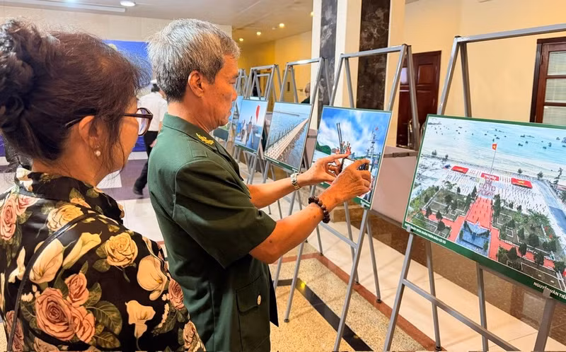 Visitors photograph some of their favourite works at the exhibition. (Photo: HA NAM)