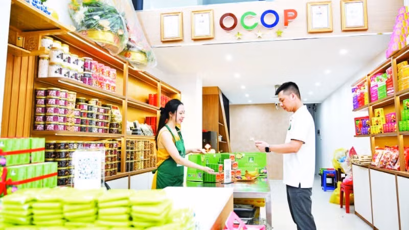 Ha Noi residents make QR-code payments at a shop (Photo: THE DAI)