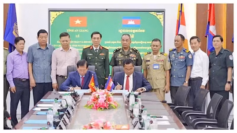 The Special Task Committees of Viet Nam's An Giang province and Cambodia's Takeo province sign a handover record for the remains of 14 Vietnamese volunteer soldiers and experts who died during wartime on July 14. (Photo: PHUONG VU)