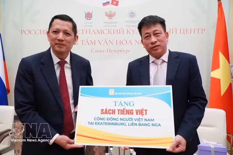 Editor-in-Chief of the Viet Nam Education Publishing House Pham Vinh Thai (right) symbolically presents books to the Vietnamese community in Russia. (Photo: TVNA)