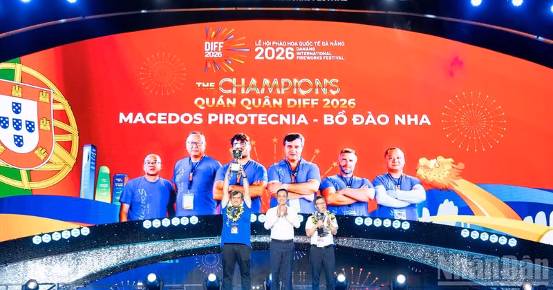 The Secretary of the Da Nang Party Committee presents the championship trophy to the Portuguese team and the runner-up award to the Chinese team.