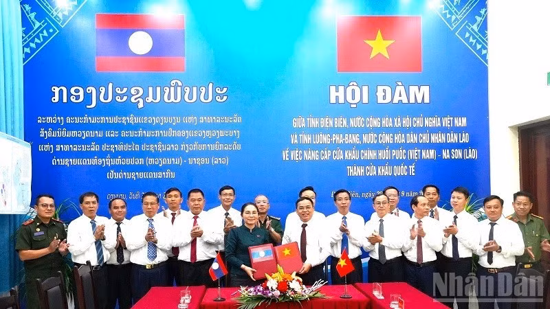 The heads of the two delegations exchange the signed minutes of the talks, agreeing to report to competent authorities on the proposed upgrade of the Huoi Puoc–Na Son main border gate pair to international status. (Photo: LE LAN)