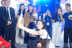 Delegates pose for a photo with robots at the event. (Photo: NDO)