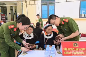 An officer of Thuan Hoa Commune Public Security guides residents in using digital transformation applications.