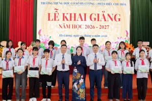 Representatives of the National Fund for Vietnamese Children and Vietcombank present scholarships to students facing difficult circumstances at the programme. (Photo: NFVC)