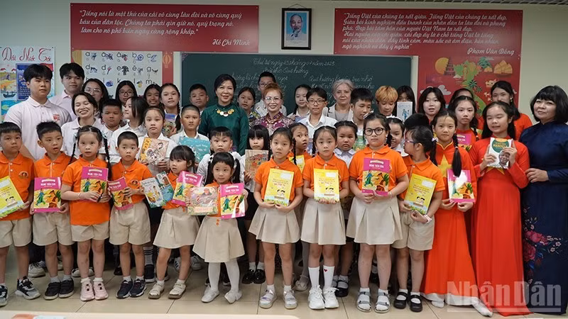 Ngo Phuong Ly presents Vietnamese books and storybooks to the children.