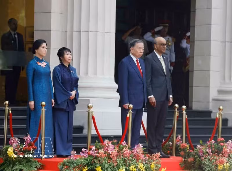 Party General Secretary and State President To Lam and Singaporean President Tharman Shanmugaratnam, together with their spouses, stand on the podium of honour as military bands perform the national anthems of Viet Nam and Singapore at the welcome ceremony on May 29 morning. (Photo: VNA)