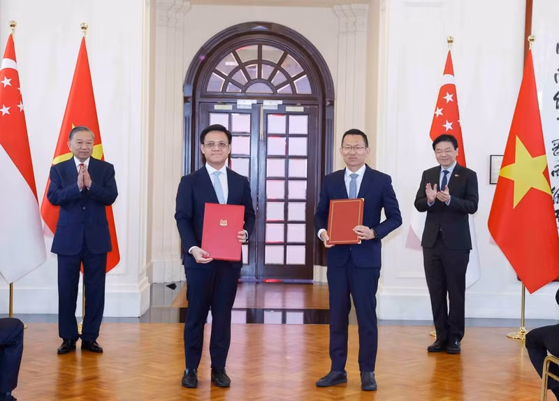 General Secretary and President To Lam and Prime Minister Lawrence Wong witness the exchange of cooperation documents between the two countries. (Photo: Thong Nhat/VNA)