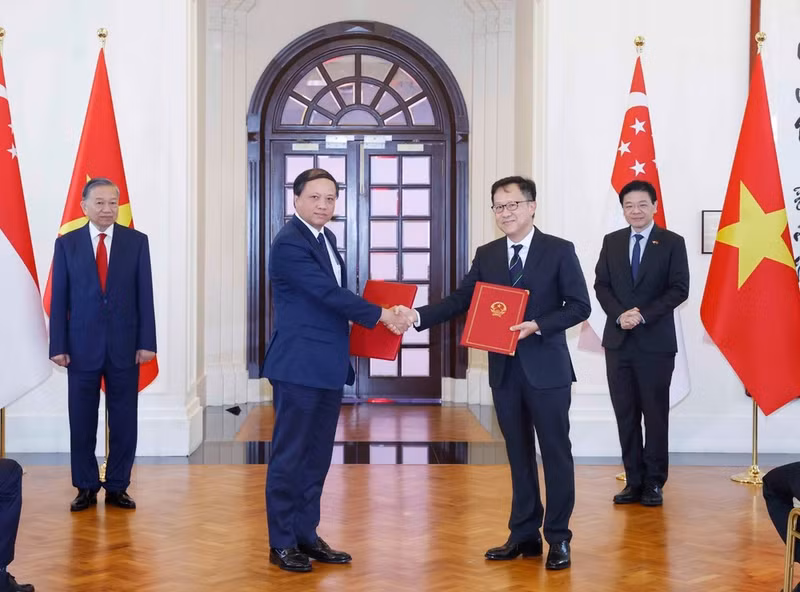General Secretary and President To Lam and Prime Minister Lawrence Wong witness the exchange of cooperation documents between the two countries. (Photo: Thong Nhat/VNA)